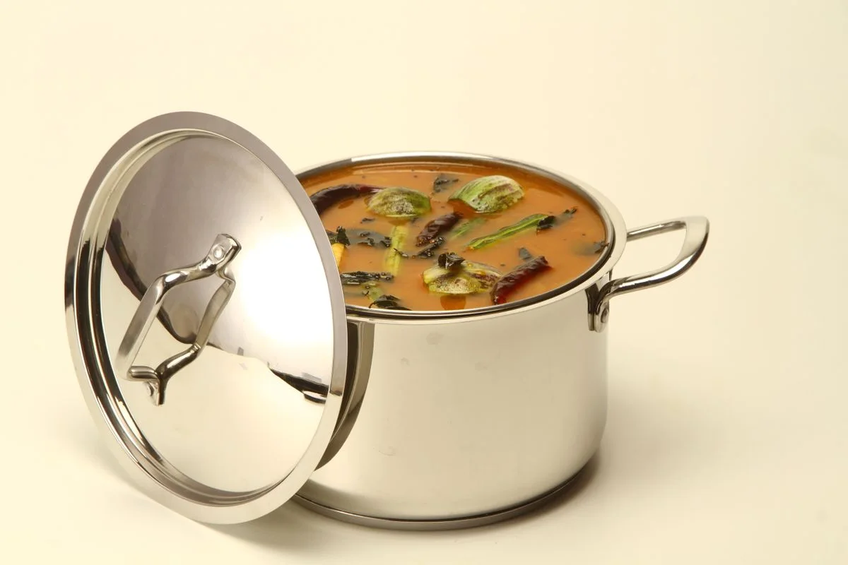 Delicious South Indian sambar curry in a stainless steel pot with colorful vegetables.