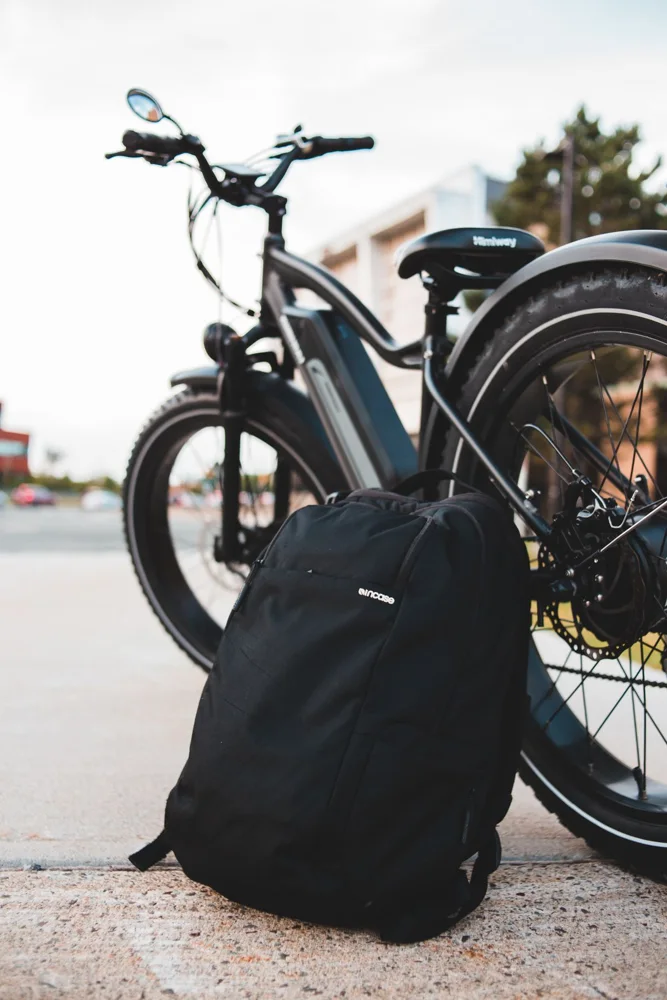 Close-up of a bicycle and backpack on an urban street.