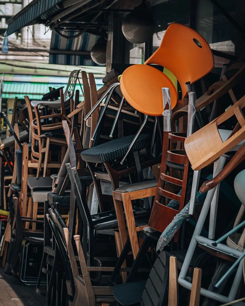 A vibrant collection of chairs stacked outside in a bustling Seoul market scene.